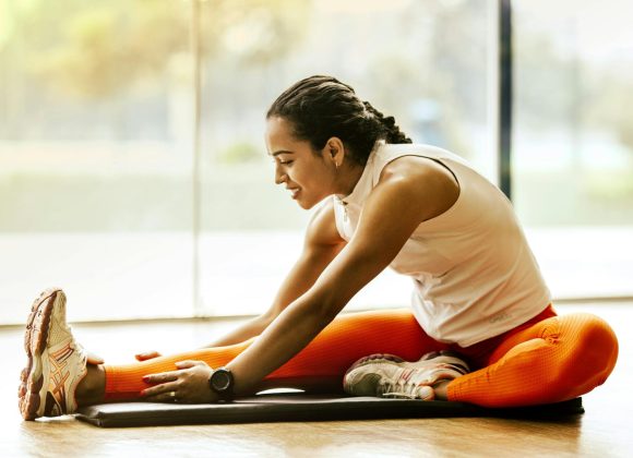 A woman enjoying a yoga stretch indoors, promoting a healthy lifestyle.