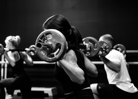 three person lifting barbels